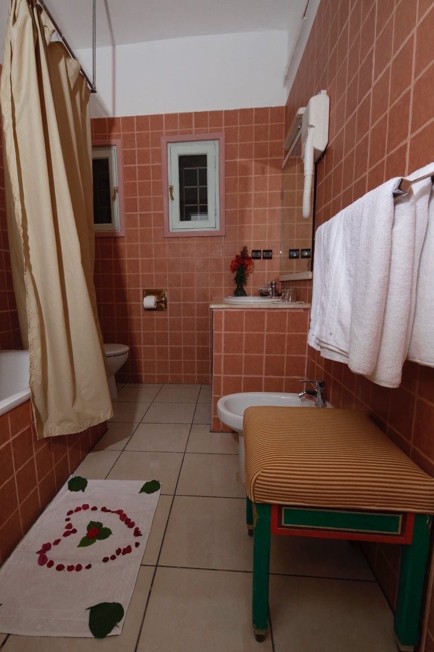 Un bagno con il water, lavandino e tenda da doccia.