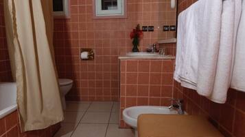 Un bagno con il water, lavandino e tenda da doccia.
