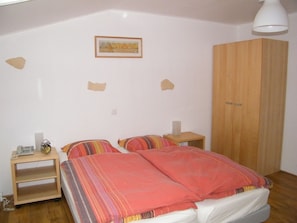 A bedroom with a bed, two bedside tables, a wardrobe, and a framed picture on the wall. - Maison Neuve Grandval (Grandval)