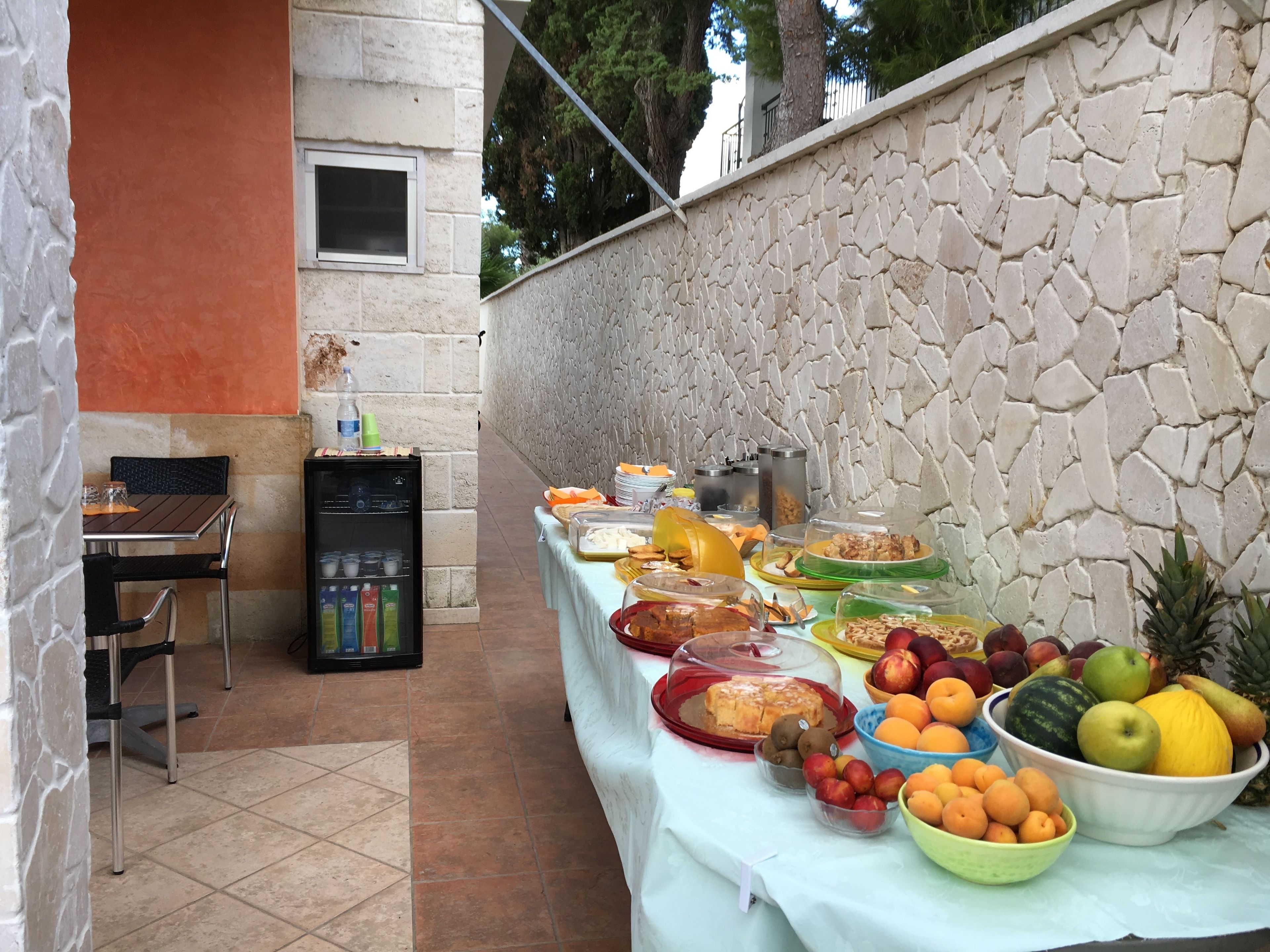 A buffet table with various food items and a refrigerator.
