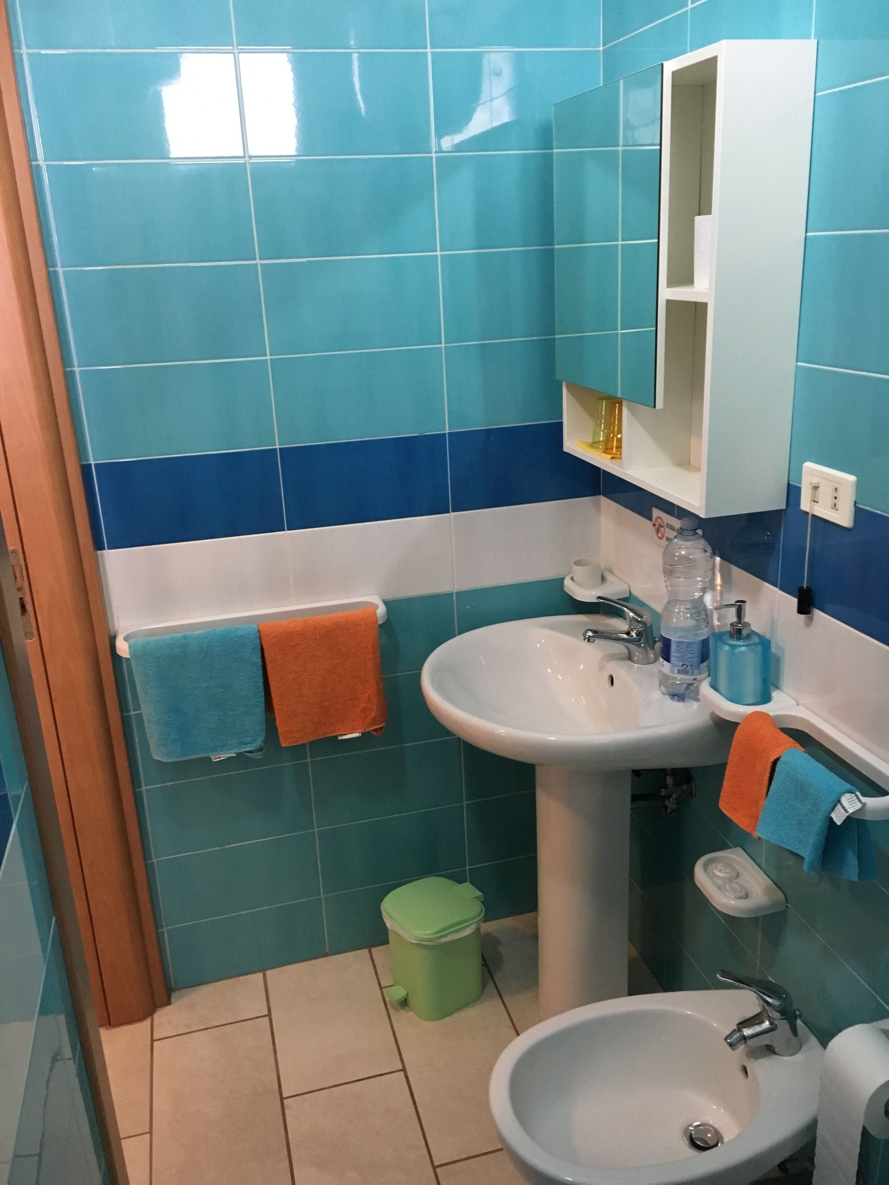 Un baño con dos orinales, un inodoro y un lavabo.