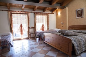 A room with two wooden beds, a chair, and a window with curtains. - Alloggio Casa Hellen (Monteforte d'Alpone)