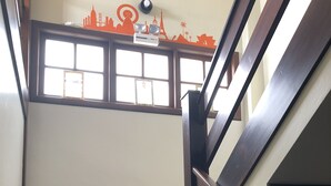 Una escalera de madera con barandilla que lleva a un rellano con ventana.