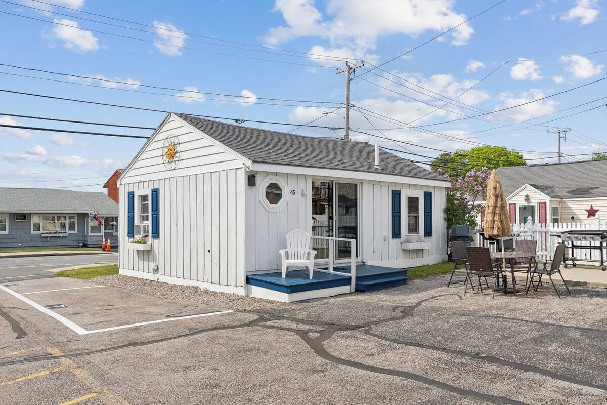 A small white building with a porch and outdoor seating area.