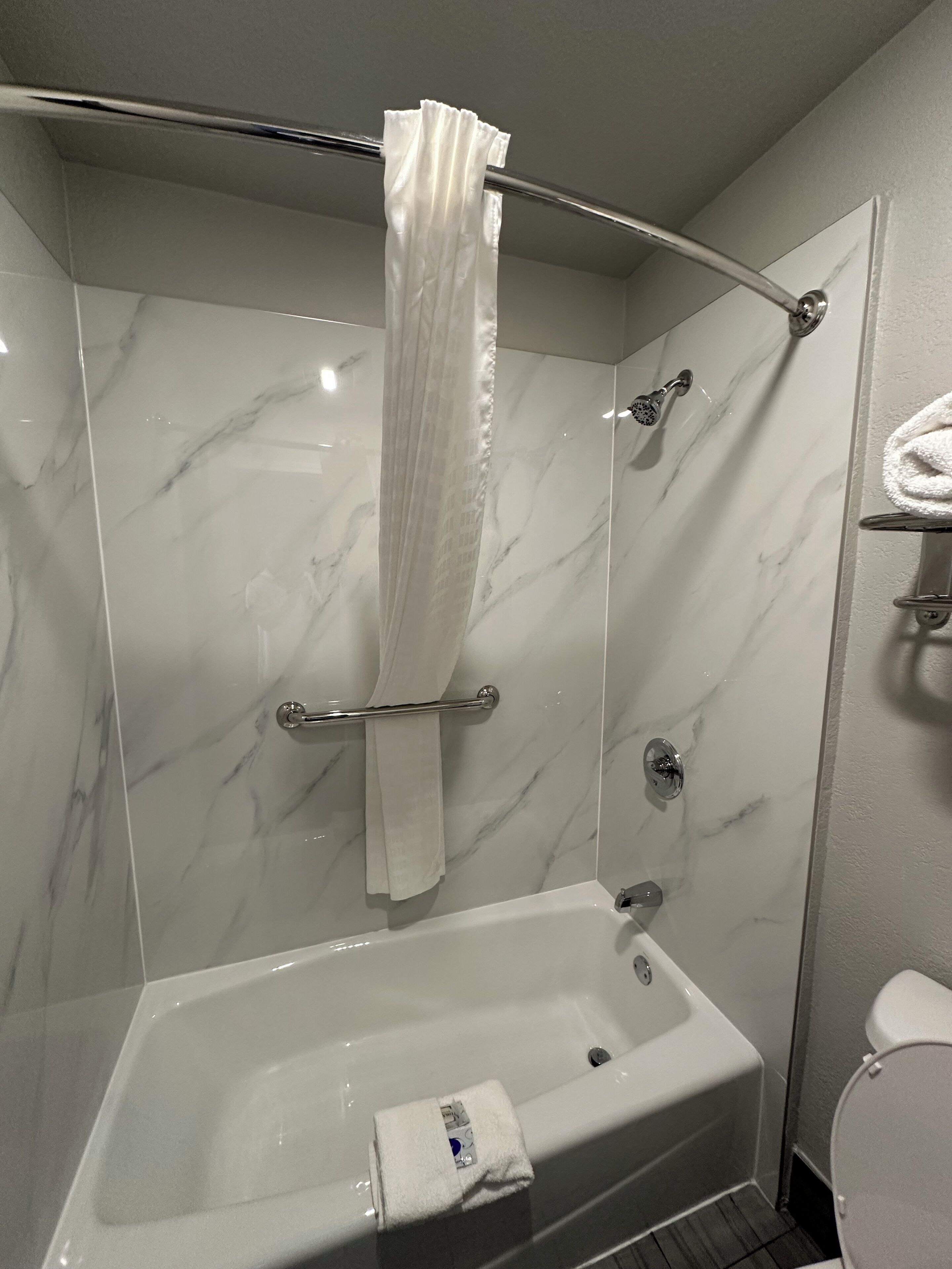 Un baño con ducha, bañera y retrete.
