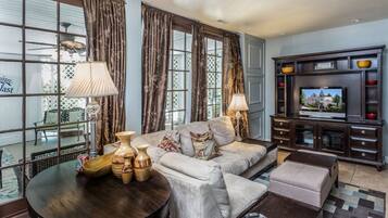 A living room with a sofa, two lamps, a coffee table, a TV, and a cabinet.