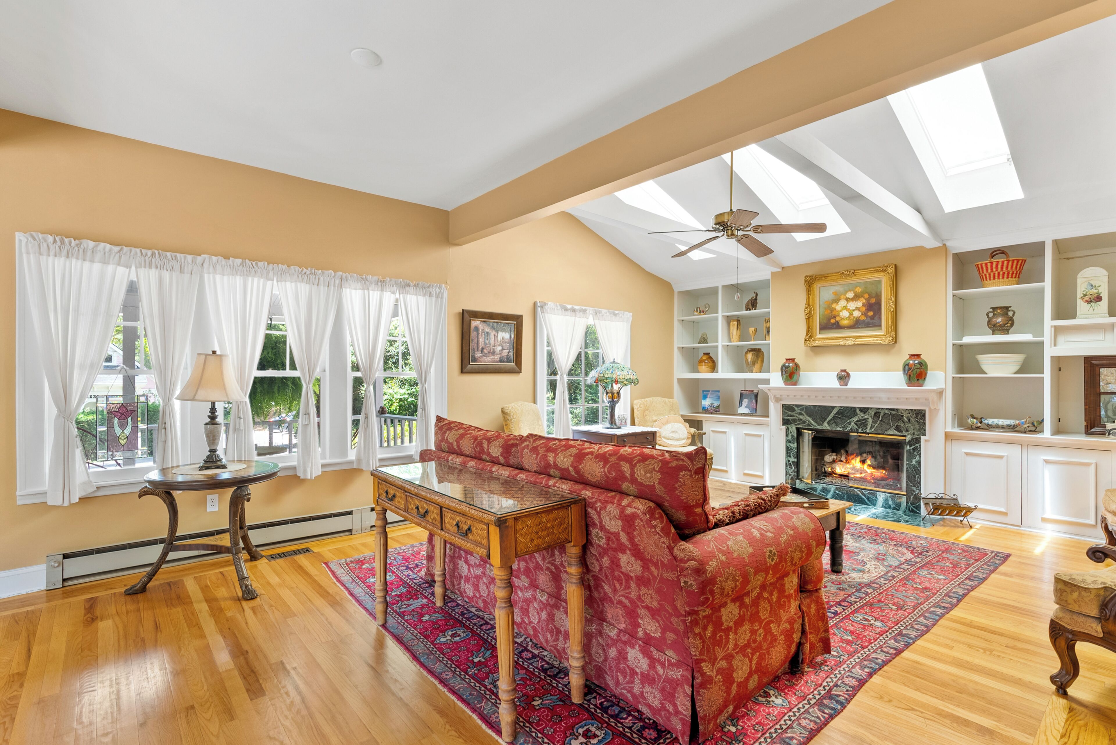 A spacious living room with a fireplace, a sofa, and a dining table.