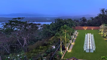 A well-maintained outdoor seating area with a view of a body of water and distant hills.