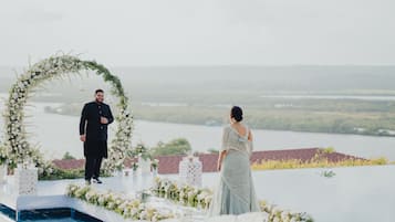 Eine Hochzeitszeremonie auf einem Dach mit Blick auf die Landschaft.
