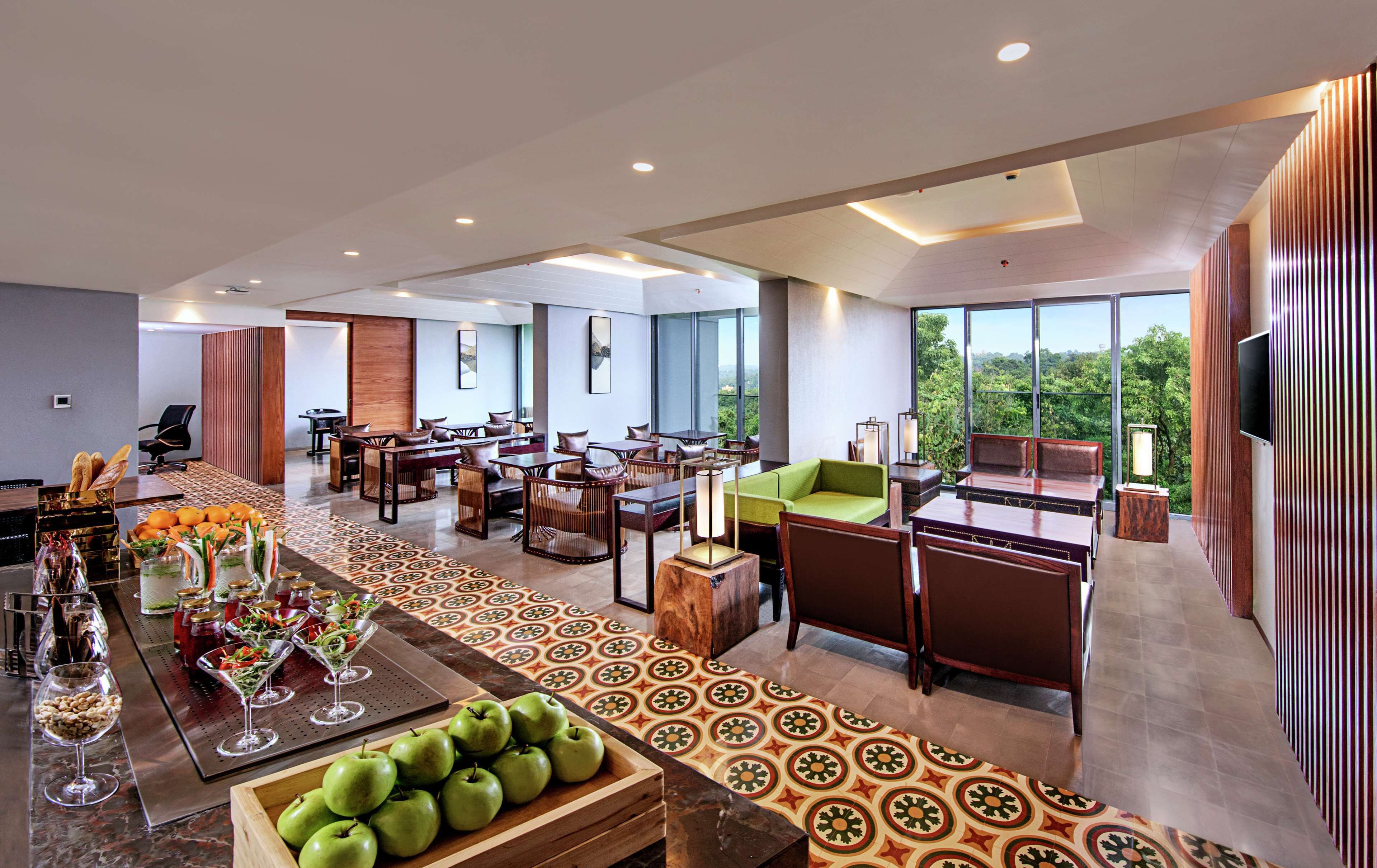 Un moderno vestíbulo de hotel con comedor, asientos y un amplio ventanal con vistas al exterior.