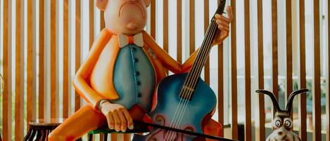 Un personaje de caricatura tocando un violonchelo en una habitación con listones de madera verticales.