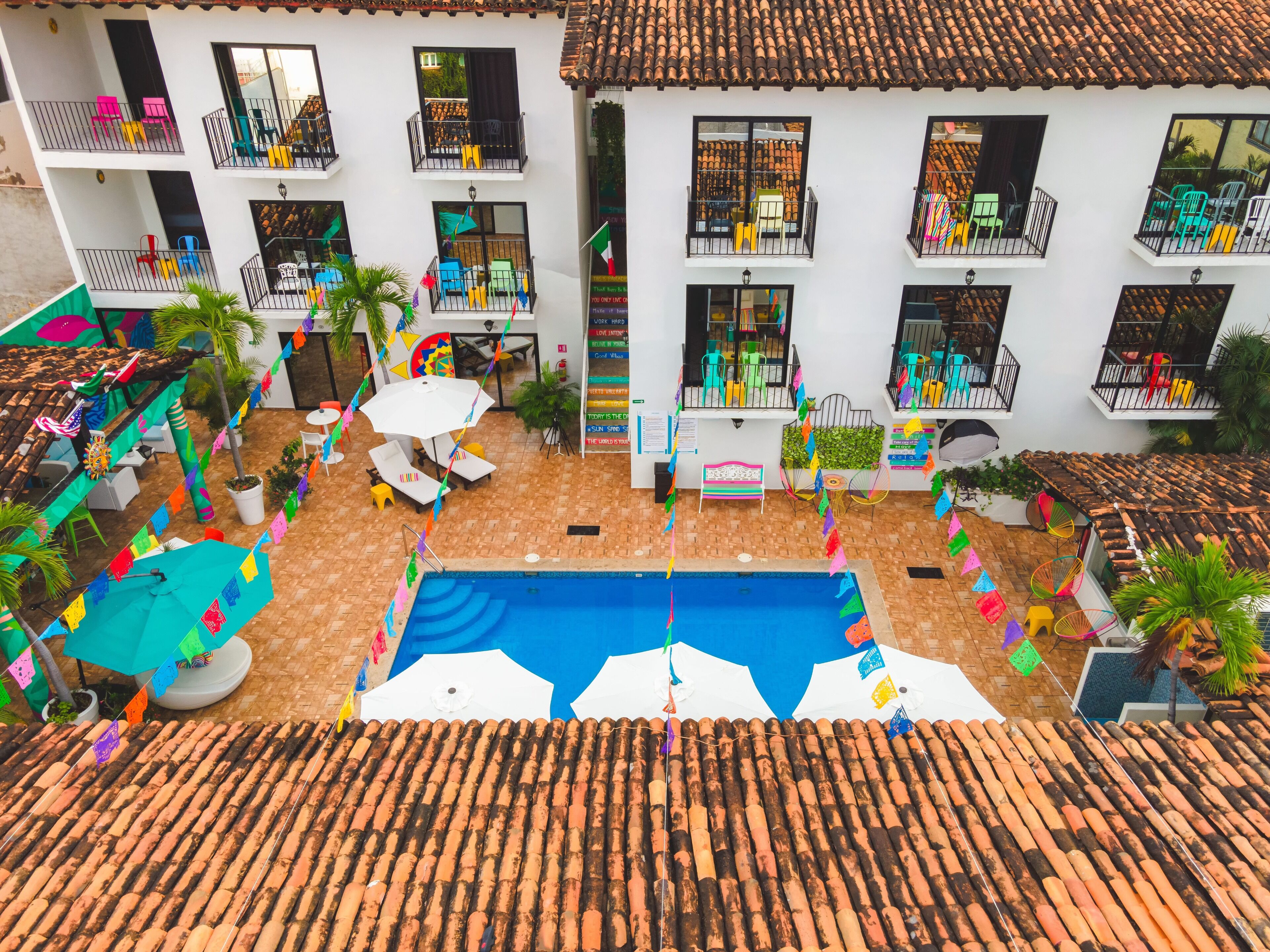 A courtyard with a swimming pool, outdoor seating, and balconies.