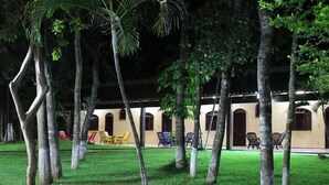 A courtyard with a building featuring arched windows and a tiled roof. - Hotel Fazenda Rio Formoso (Bonito)