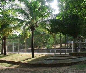 A fenced outdoor area with palm trees and a brick platform. - Hotel Fazenda Rio Formoso (Bonito)