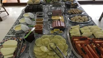 En buffet med forskellige retter, herunder kød, oste og frugt.