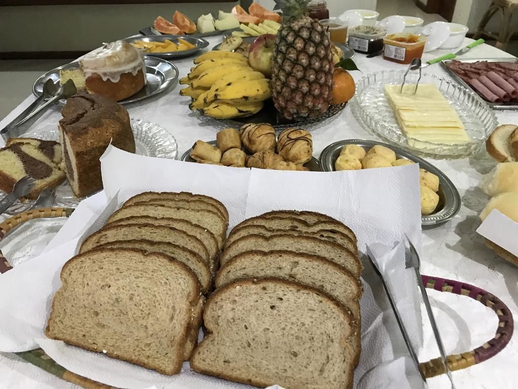 A buffet table with various food items including bread, fruits, and pastries.