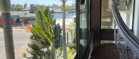 Una habitación con vistas a la calle, una hamaca y una ventana que da a un jardín.
