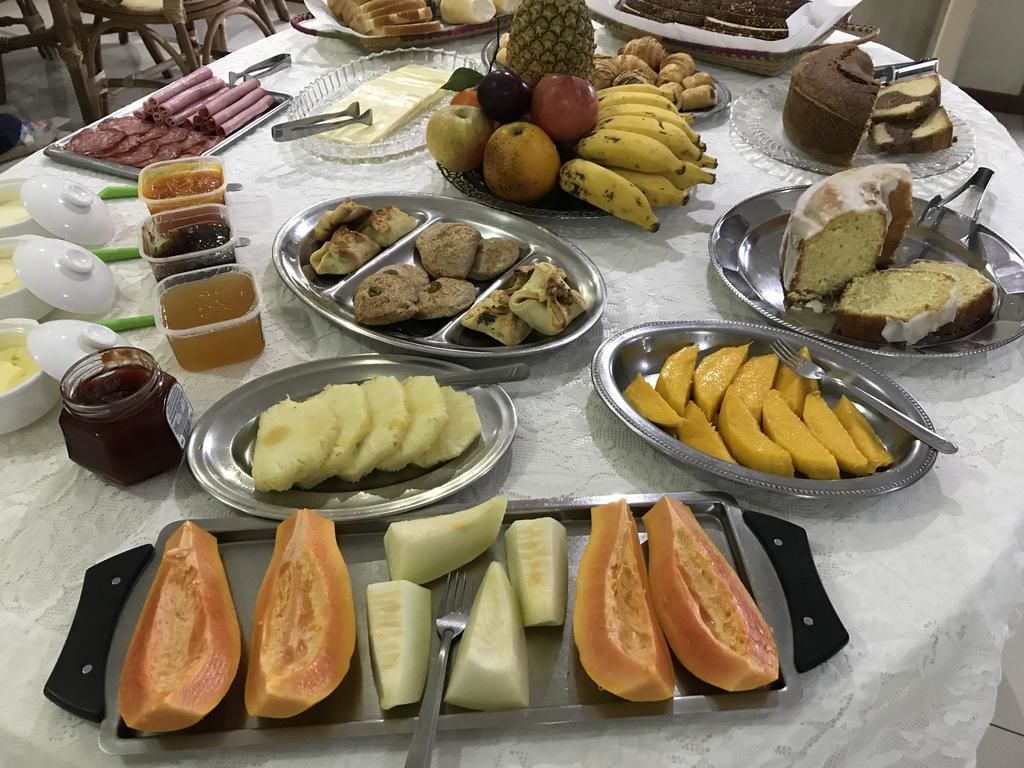 Una mesa de buffet con diversas opciones de comida, incluyendo frutas, pasteles y salsas.