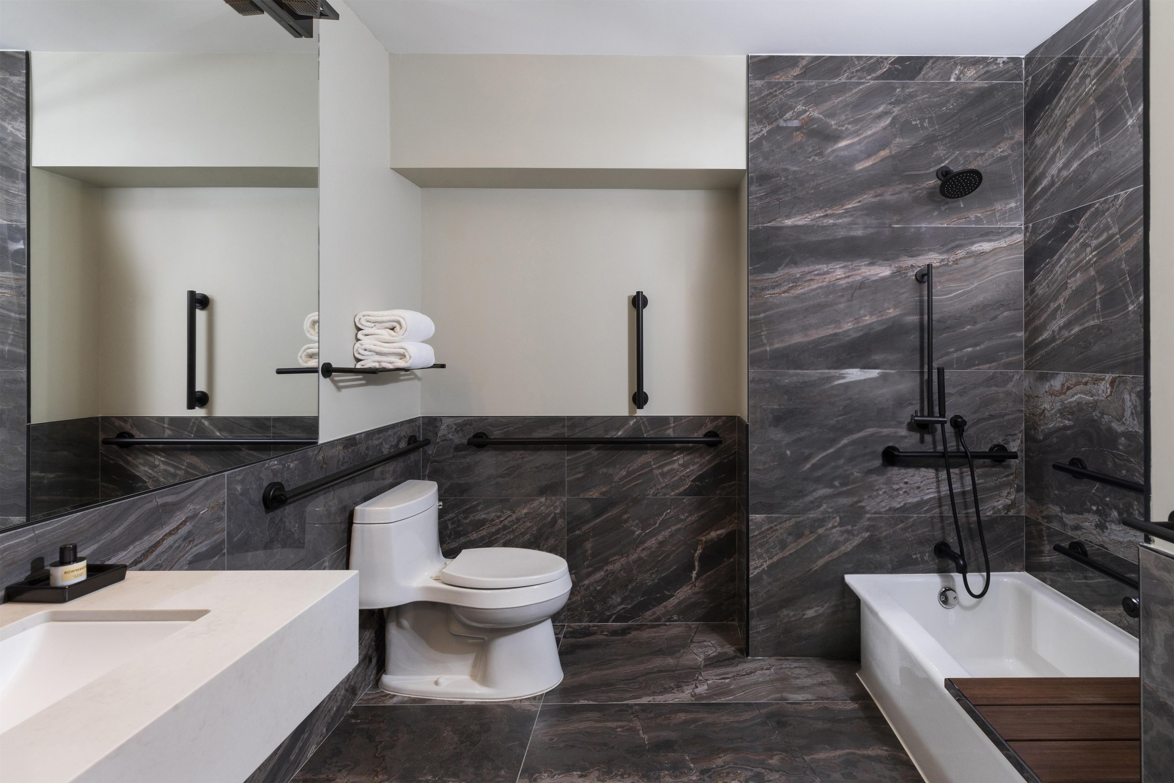 Ein modernes Badezimmer mit Toilette, Waschbecken und Badewanne.