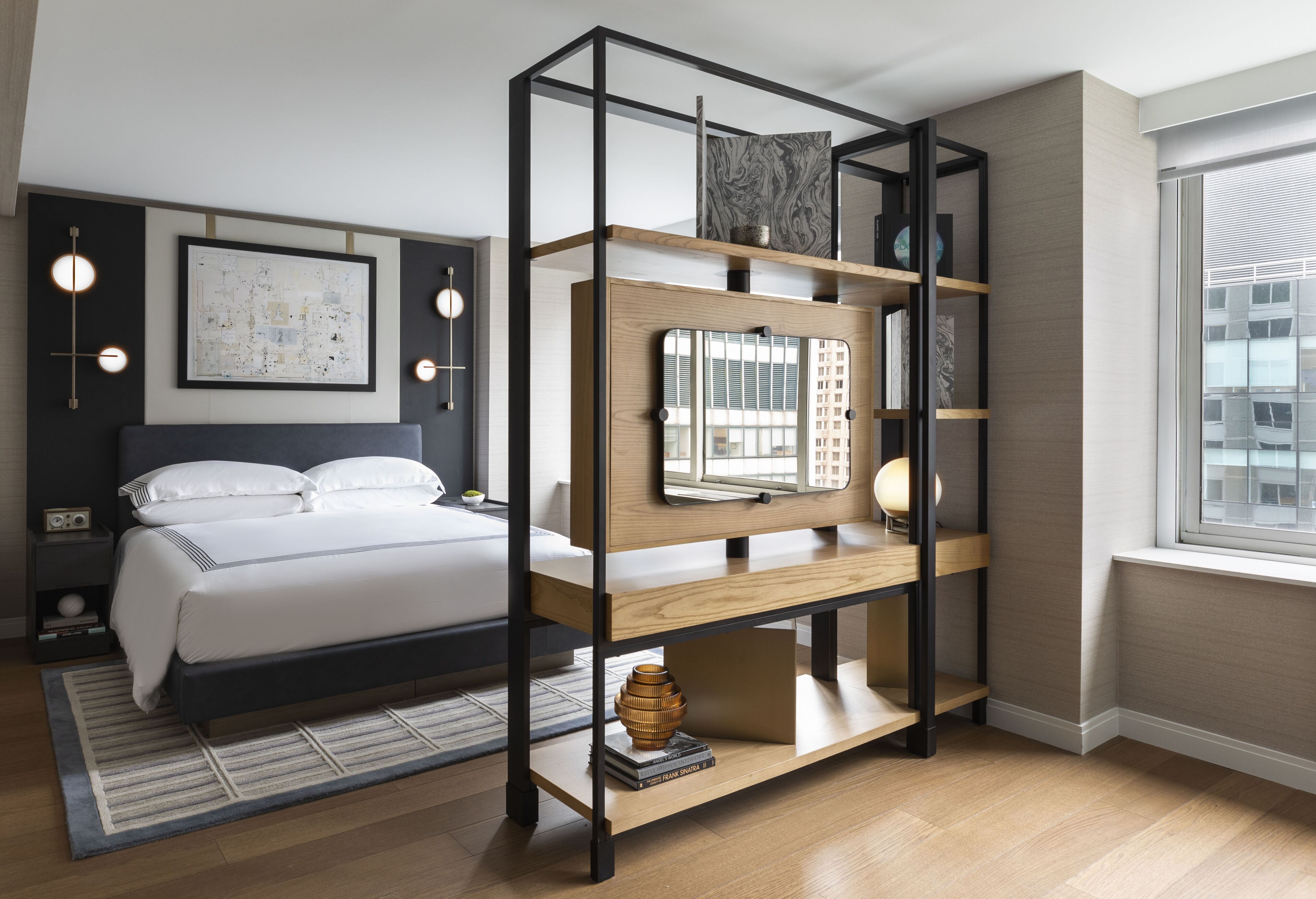 A modern bedroom with a bed, a wooden TV stand, and a city view.