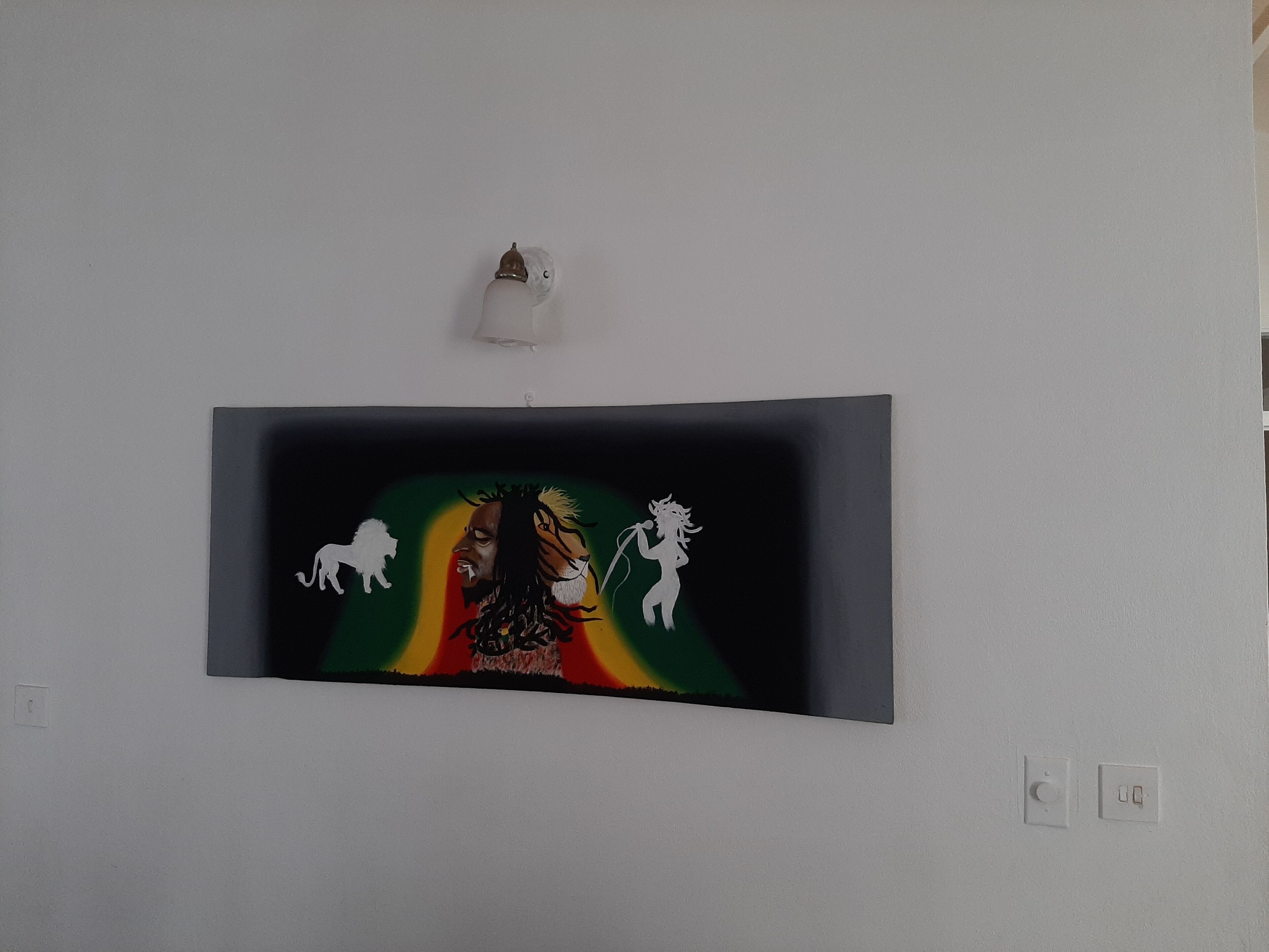 A wall-mounted artwork featuring a central figure with a lion and a woman, surrounded by abstract shapes and colors.