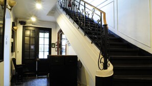 A staircase with black railings and a white handrail, leading to a room with a black door and a window.