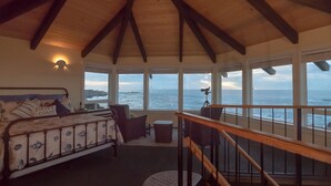 Ein Schlafzimmer mit einem Bett, einem Schreibtisch und Blick aufs Meer.