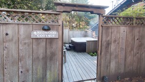 A wooden gate with a sign reading "Redwood Cottage."