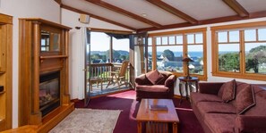 Una sala de estar acogedora con chimenea, un ventanal con vistas y asientos cómodos.