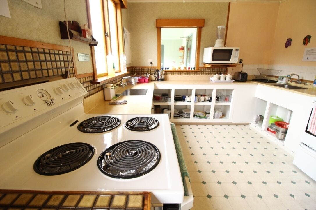 A kitchen with a white stove, a microwave, and a tiled backsplash.