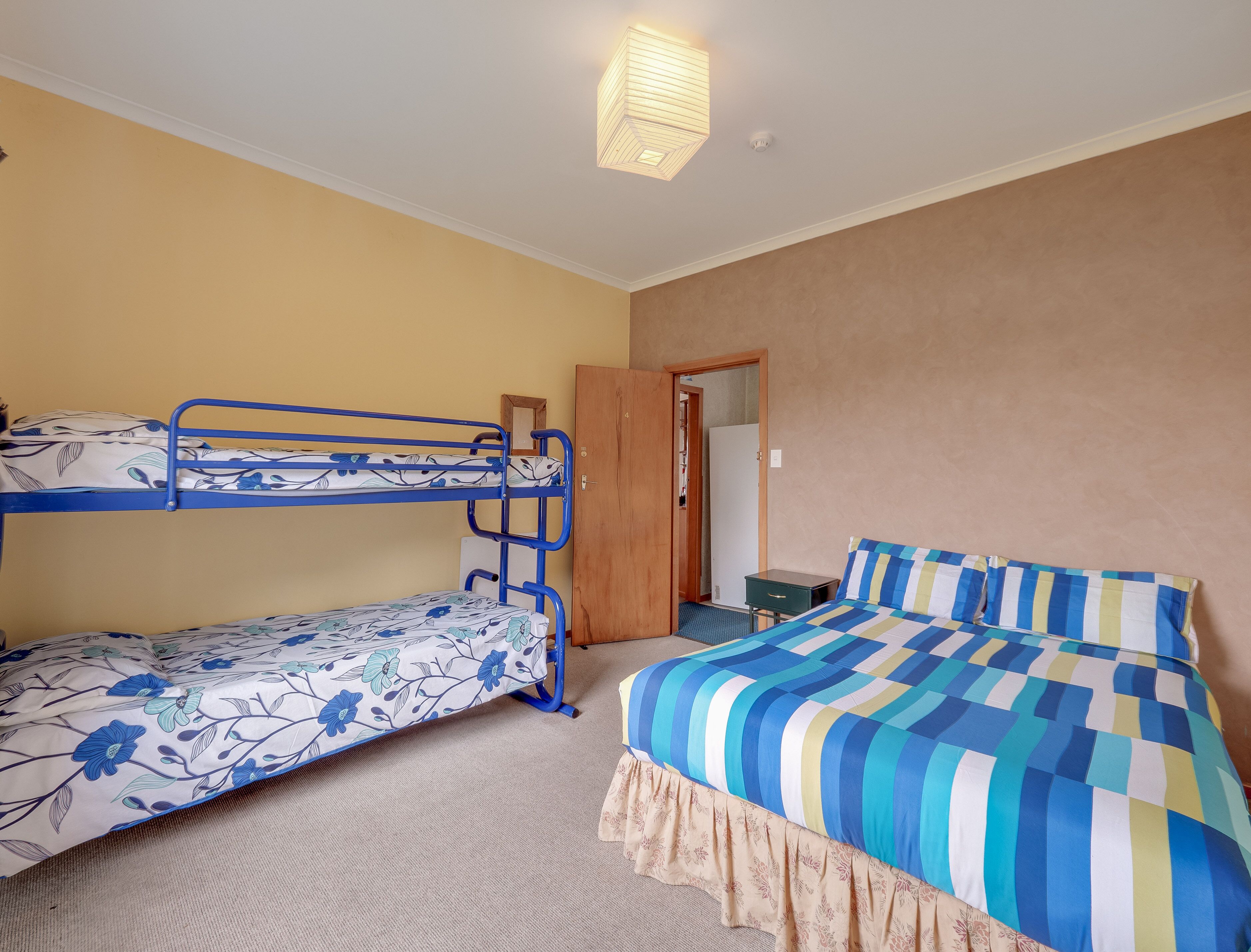 A room with bunk beds, a desk, and a wardrobe.