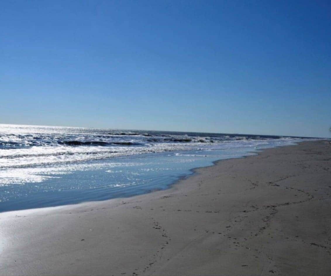 A beach with a clear sky and calm sea.