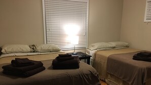 A hotel room with two beds, a bedside table with a lamp, and a window with blinds. - Awesome remodeled house! (Mentor)