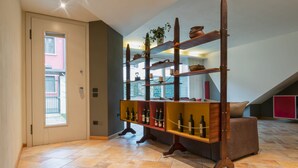 Una habitación con un botellero de madera, un sofá y una puerta con ventana.