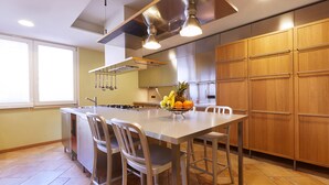 Una cocina moderna con una isla central, electrodomésticos de acero inoxidable y armarios de madera.