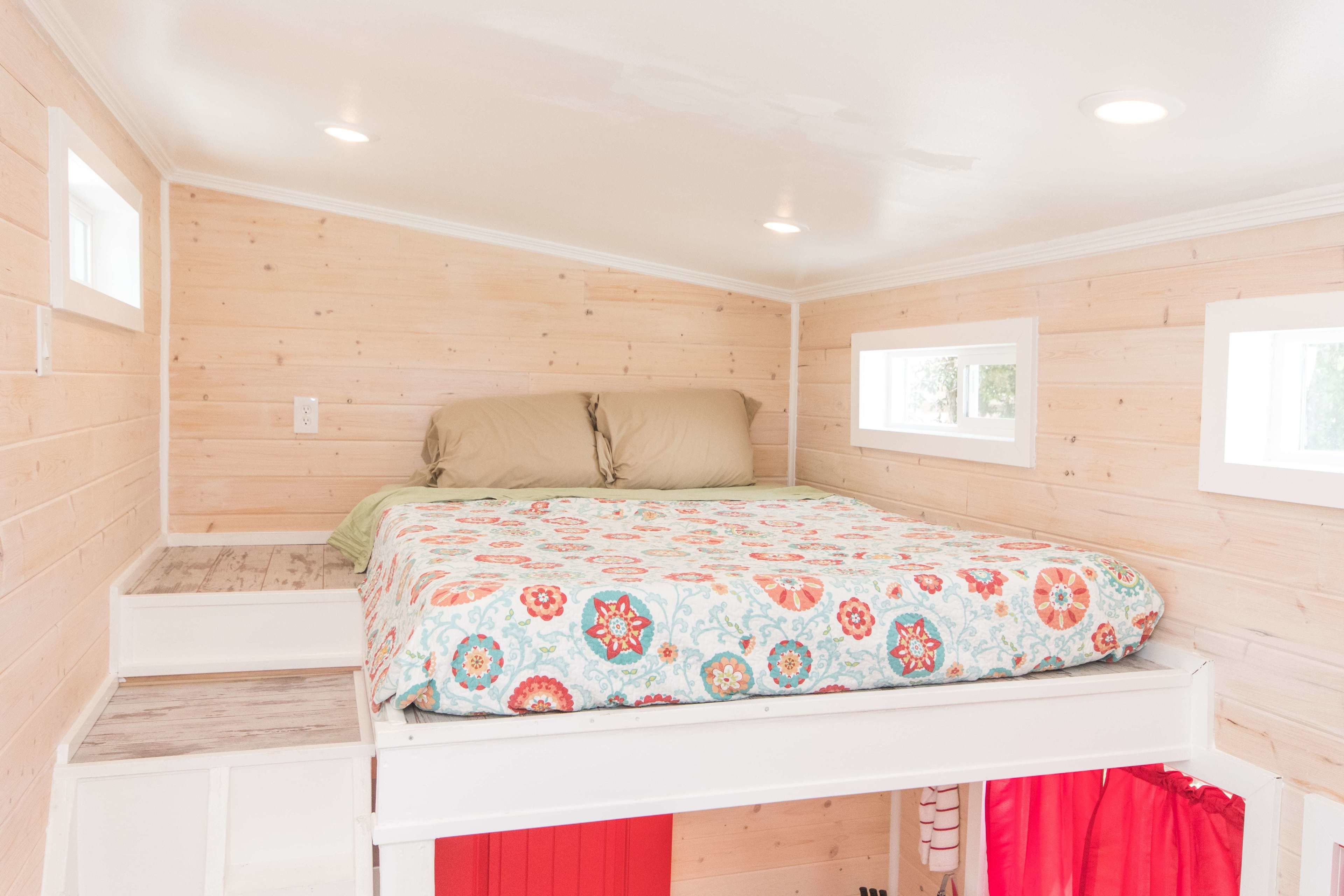 Une chambre à coucher avec un lit, une fenêtre et un mur en bois.