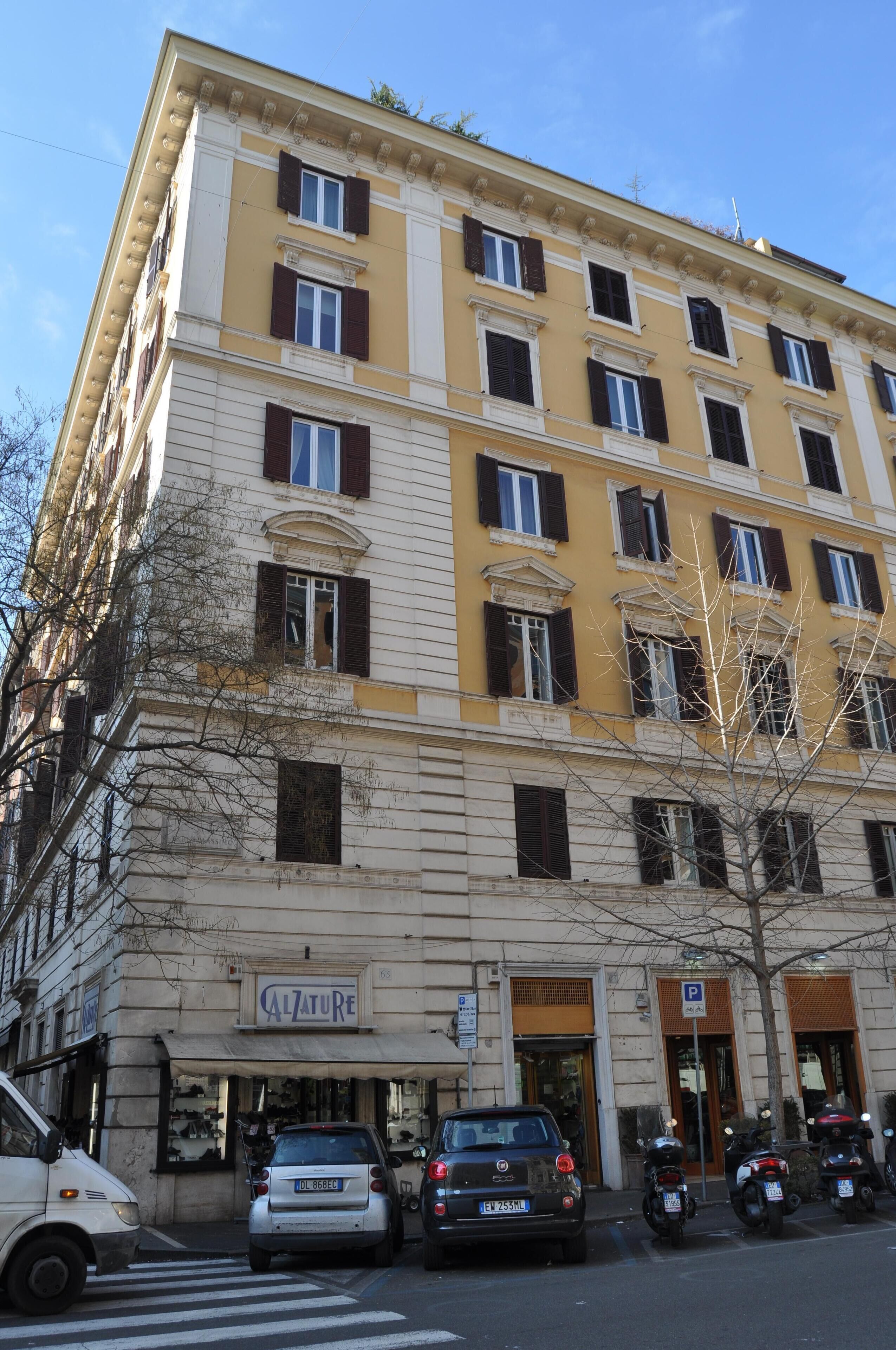 Ein mehrstöckiges Gebäude mit einer Schaufensterfront, auf der "Calzature" steht.