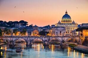 A historic bridge with multiple arches over a river, leading to a large domed building with classical architecture. - ROME BOUTIQUE APARTMENTS comfortable, cozy, central, 8minutes from the vatican (Roma)
