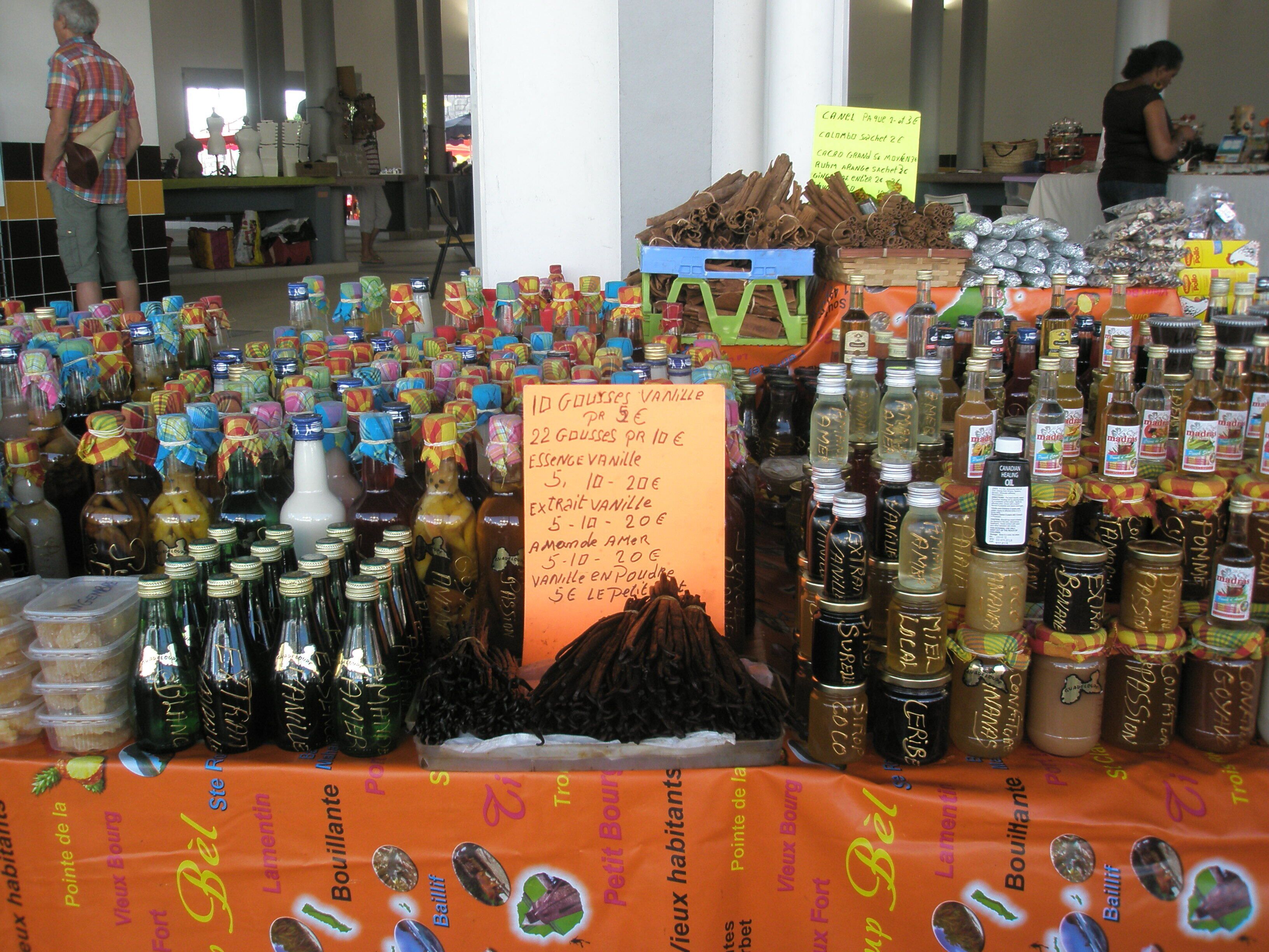 Un puesto de mercado con varias botellas y frascos, probablemente conteniendo alimentos o condimentos.