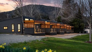 A modern building with multiple units, each featuring large windows and wooden accents. - Bright Riverside Holiday Park (Bright)