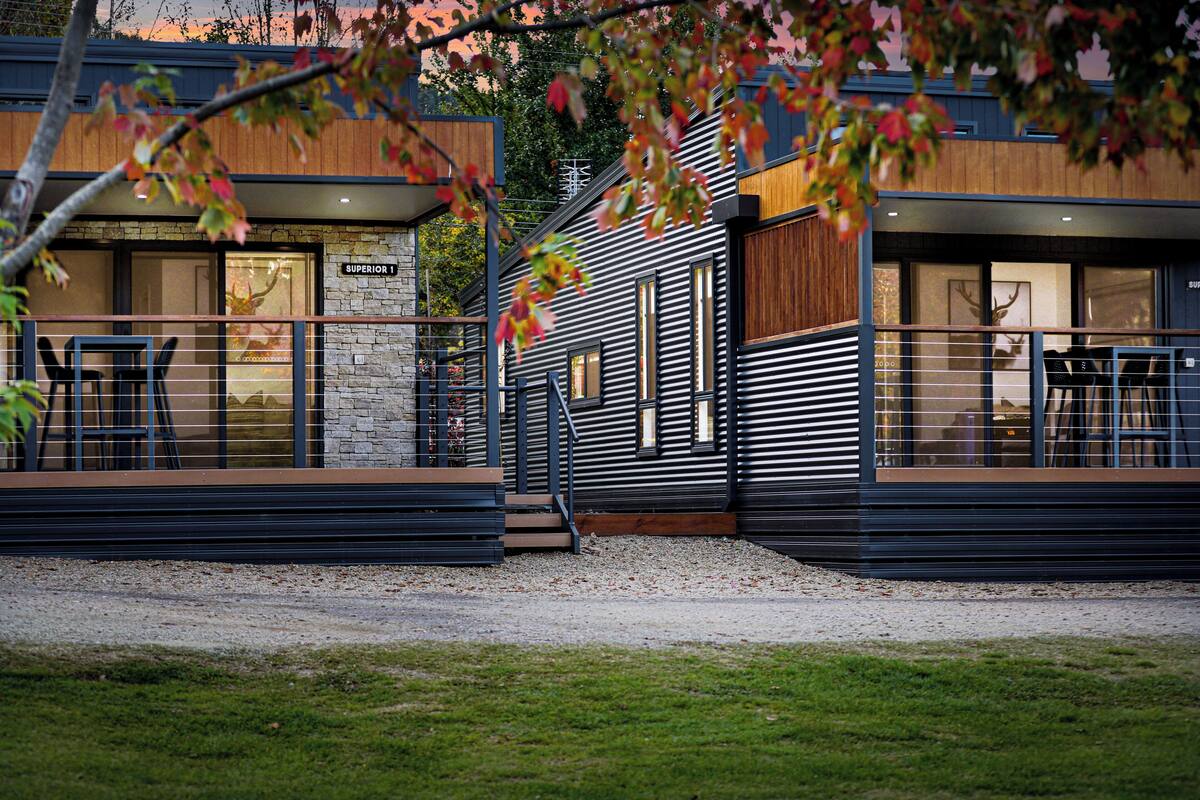 A modern building with a stone facade, wooden accents, and a metal railing.