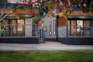 A modern building with a stone facade, wooden accents, and a metal railing.