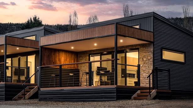 A modern two-story house with a stone facade, large windows, and a balcony. - Bright Riverside Holiday Park (Bright)
