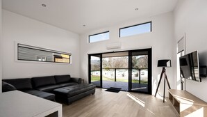 A modern living room with a sectional sofa, a wooden coffee table, and a tripod. - Bright Riverside Holiday Park (Bright)
