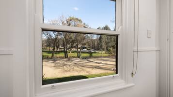 Una ventana con vista a un parque y una calle.