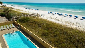 A swimming pool adjacent to a beach with umbrellas and lounge chairs. - Summerlin-Beachfront for Late Summer!  5 Star! (Fort Walton Beach)