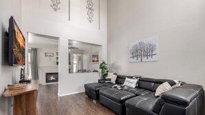 Ein modernes Wohnzimmer mit einem Ecksofa, einem Kamin und Kunstwerken an den Wänden.