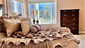 A bedroom with a large bed, a dresser, and a chandelier. - Movie Theater! Hot Tub! Private Rental 3 Bedrooms and 2 Bathrooms. (Bellingham)