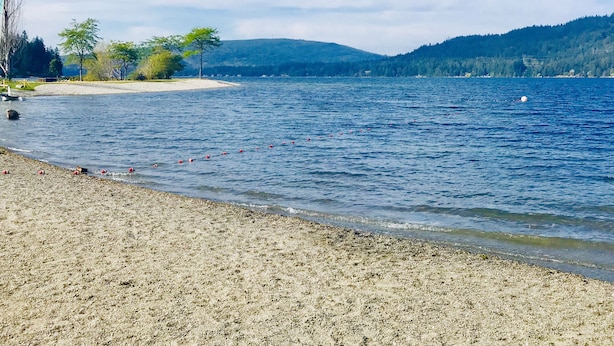 A beach with a clear view of the water and distant hills. - Movie Theater! Hot Tub! Private Rental 3 Bedrooms and 2 Bathrooms. (Bellingham)