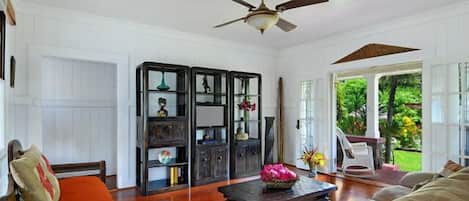 A spacious living room with a ceiling fan, a wooden coffee table, and a sofa.